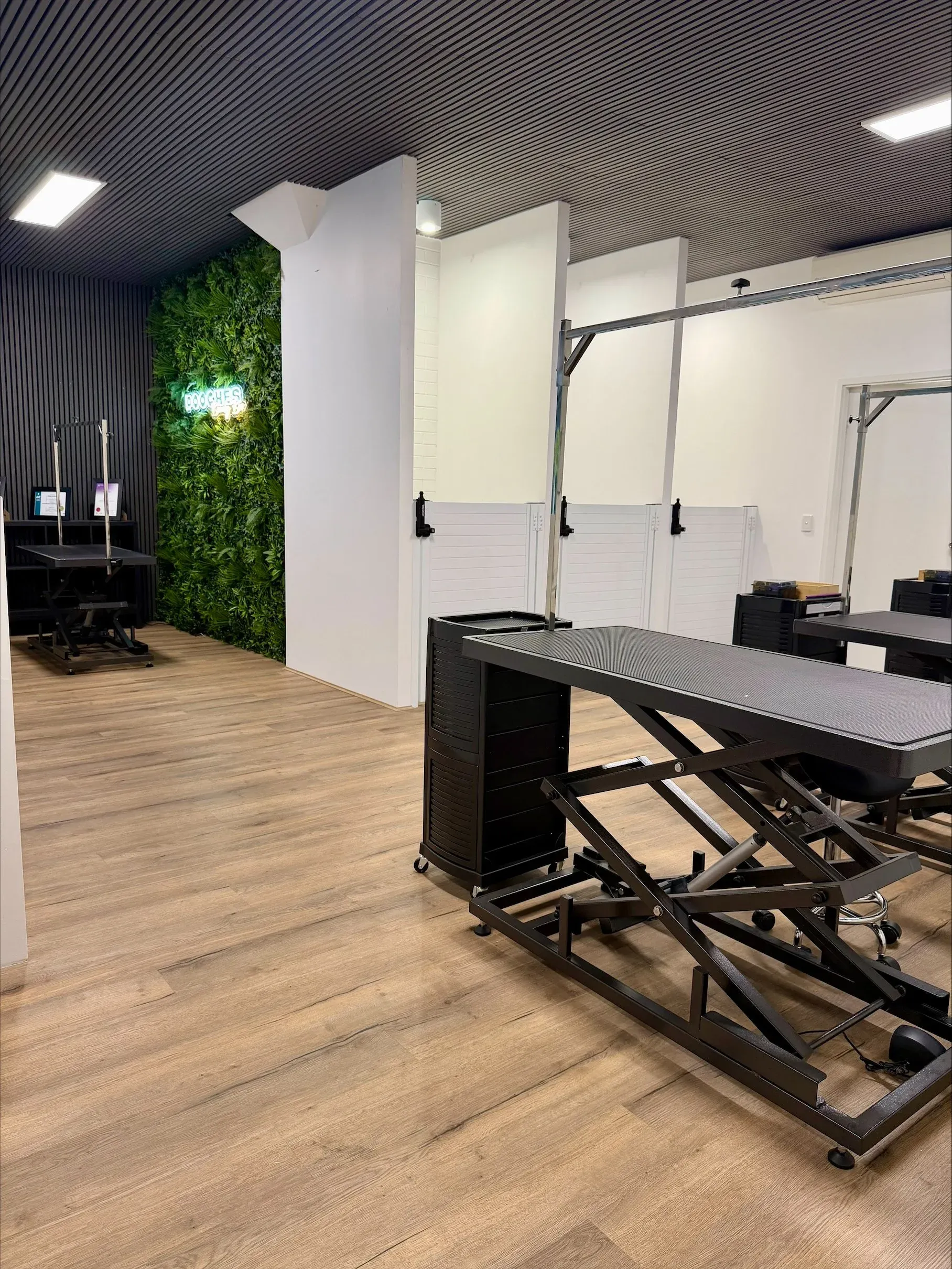 The main grooming room with hydraulic tables and oak flooring