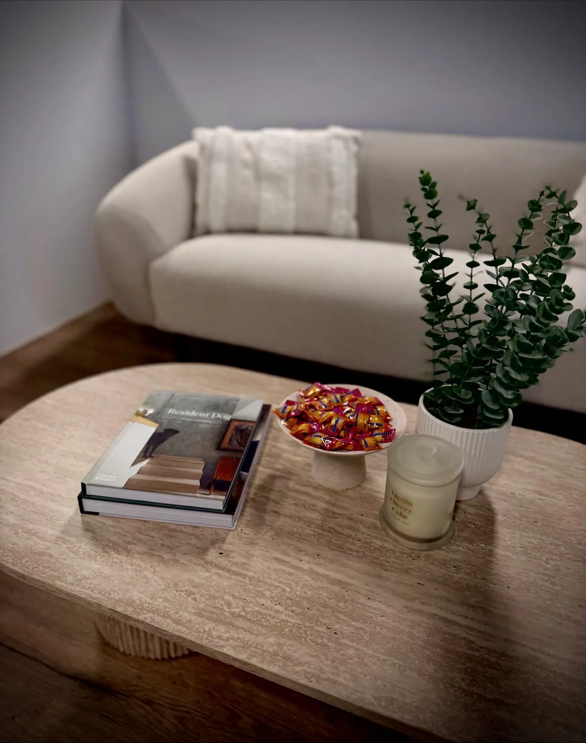 The waiting area with a soft couch, magazines and a candle